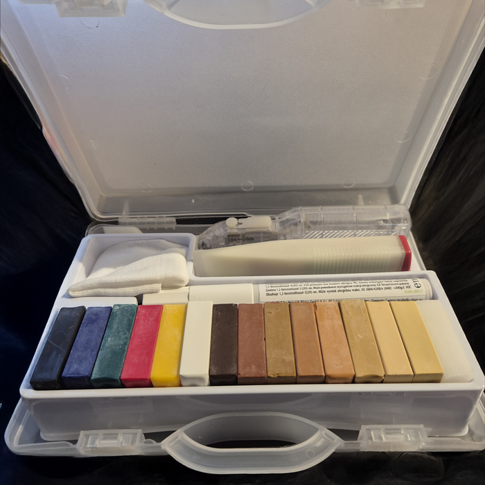 Premium Wood Repair Kit open in its clear case, with coloured hard wax sticks, a battery melter, a cloth and a lacquer pen