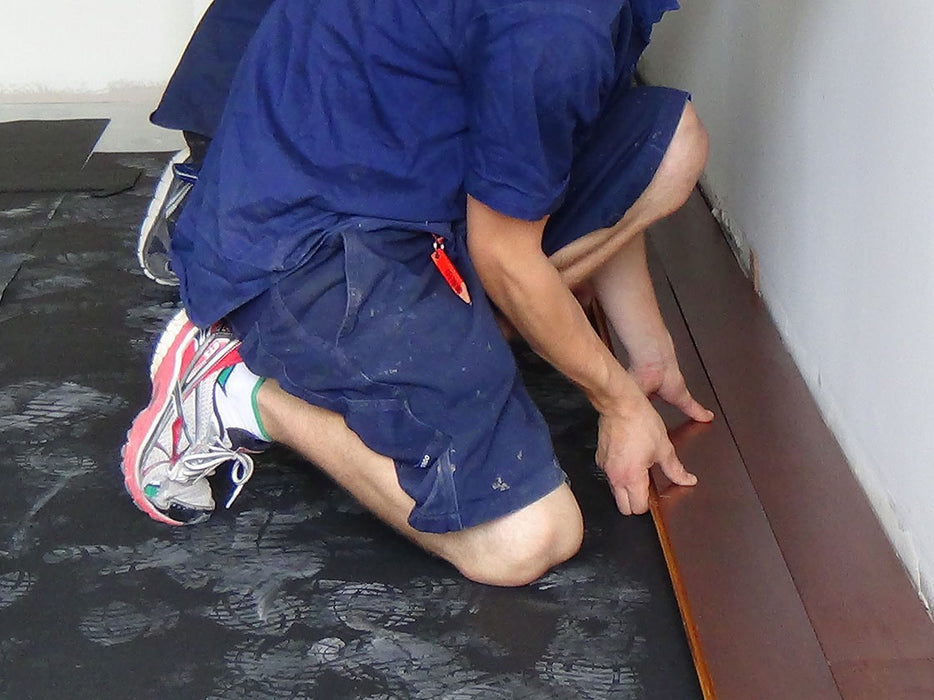 AcoustaMat acoustic underlay being installed under timber flooring